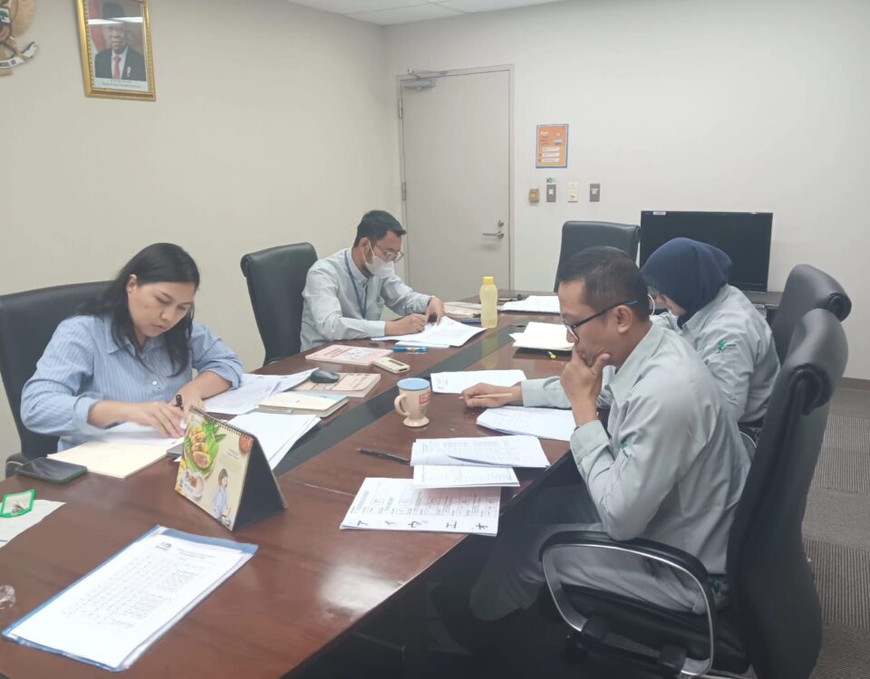 Beberapa karyawan industri sedang mengikuti sesi pelatihan bahasa Jepang secara serius di ruang rapat sebagai persiapan menjelang tugas ke Jepang.