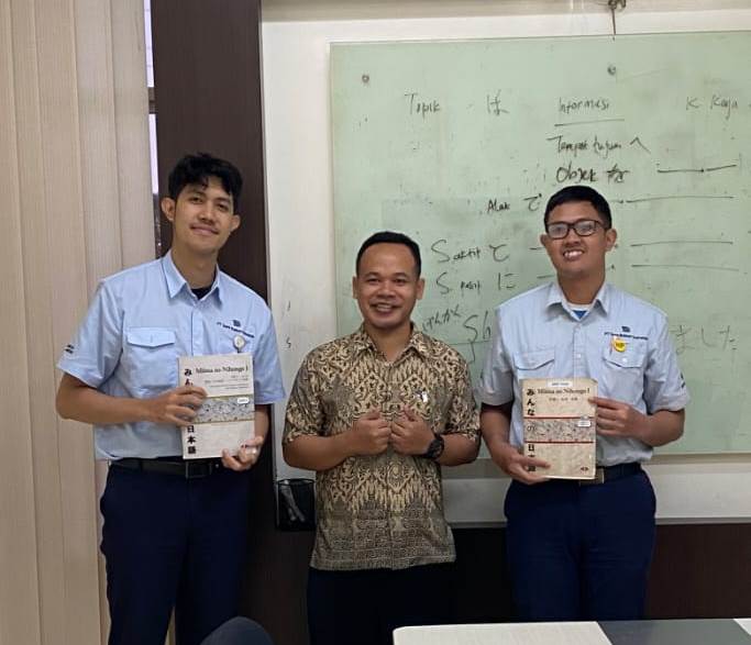 Dua peserta pelatihan berfoto bersama instruktur setelah menyelesaikan sesi belajar bahasa Jepang dalam program persiapan training di perusahaan induk Jepang.