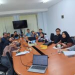Peserta pelatihan bahasa Jepang in house duduk di ruang rapat, berpose santai bersama instruktur di tengah sesi pelatihan di perusahaan manufaktur.