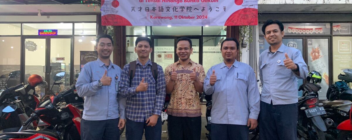 Peserta pelatihan bahasa Jepang untuk karyawan baru berfoto di depan spanduk pelatihan di Tensai Nihongo Bunka Gakuin.