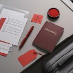 Dokumen visa SSW terbaru: flat-lay profesional tanpa teks menyorot paspor, map dokumen, stempel, dan tag merah jelang keberangkatan